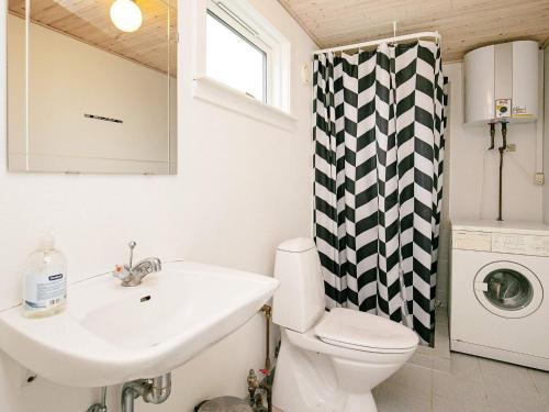 a bathroom with a sink and a toilet and a washing machine at Three-Bedroom Holiday home in Væggerløse 6 in Bøtø By