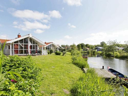 a house next to a river with a bridge at 6 person holiday home in Otterndorf in Otterndorf
