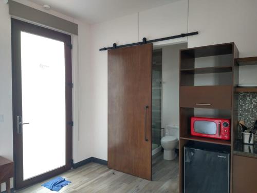 a room with a bathroom with a red tv on a counter at Suite Loft Deslumbrante Salida a México 102A in Querétaro