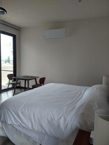 a bedroom with a white bed and a table at Suite Loft Deslumbrante Salida a México 102A in Querétaro