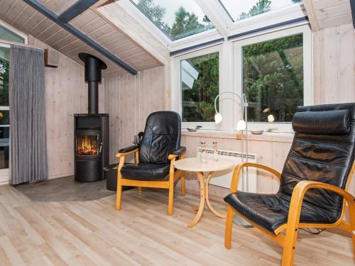 Habitación con mesa, sillas y fogones. en 8 person holiday home in Bl vand, en Blåvand