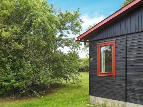 ノーポにある6 person holiday home in Nordborgの赤い窓のある黒い家