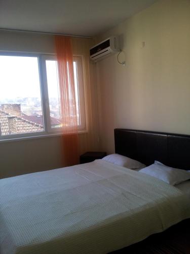 a bedroom with a bed with a large window at Sandanski Peak Guest Rooms in Sandanski