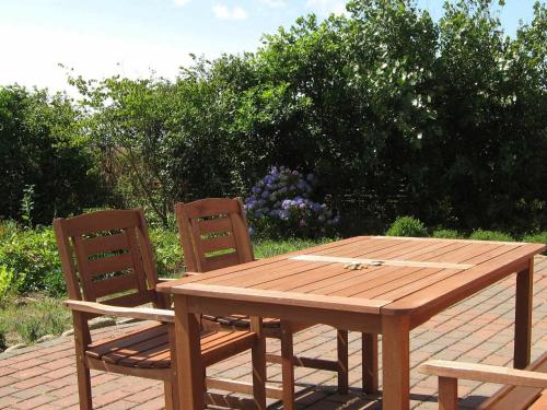 una mesa de madera y 2 sillas en un patio de ladrillo en 4 person holiday home in Lemvig, en Trans