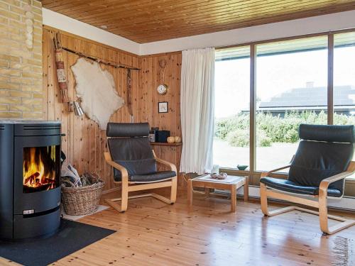 a living room with two chairs and a fireplace at 7 person holiday home in Knebel in Knebel