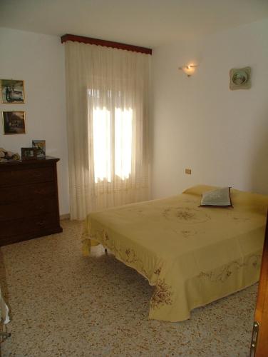 a bedroom with a bed and a dresser and a window at Casa Giordano in Guardavalle