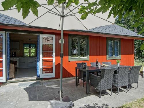 een patio met een tafel en stoelen met een parasol bij 6 person holiday home in Nex in Snogebæk