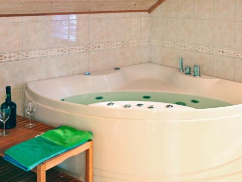een badkamer met een bad en een groene handdoek bij Four-Bedroom Holiday home in Sirevåg in Sirevåg