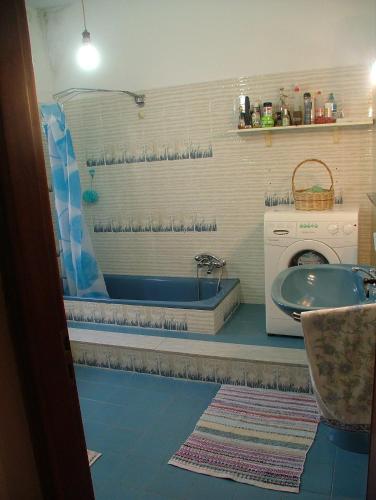 a bathroom with a tub and a sink and a washing machine at Casa Giordano in Guardavalle