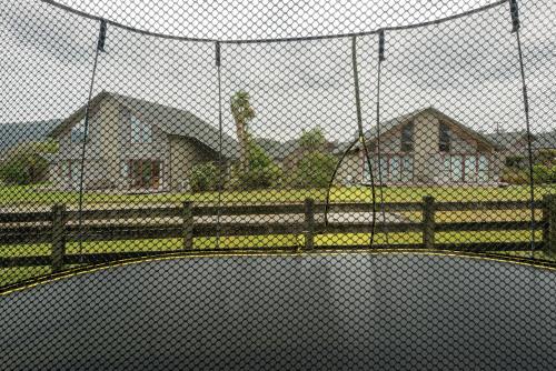 a tennis court behind a chain link fence at Glenfern Villas in Franz Josef