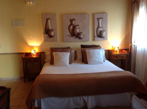 a bedroom with a bed with vases on the wall at Posada el Campanario in Rascafría