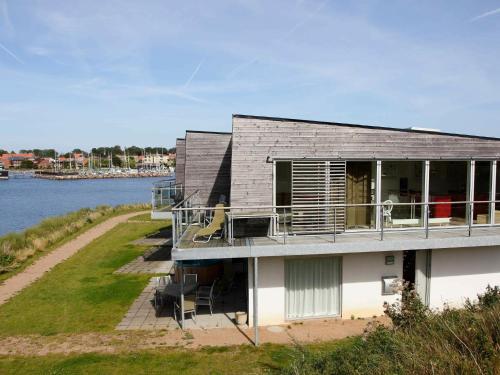 a house with a balcony and a river at 7 person holiday home in Stege in Stege