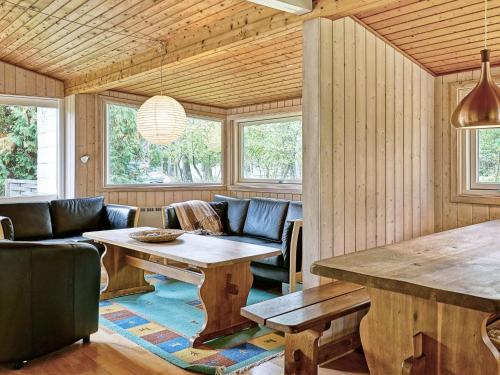 a living room with a wooden table and chairs at Cozy Holiday Home in Aakirkeby Bornholm near the Sea in Vester Sømarken