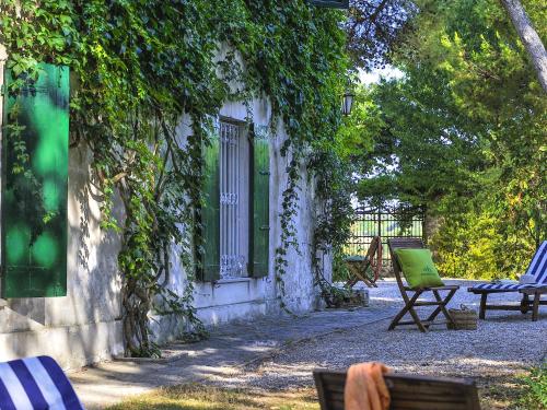 a yard with chairs and a building with vines at Belvilla by OYO Monti in Senigallia