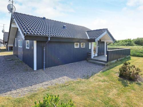 a small house with a black roof at 6 person holiday home in Ringk bing in Nørby