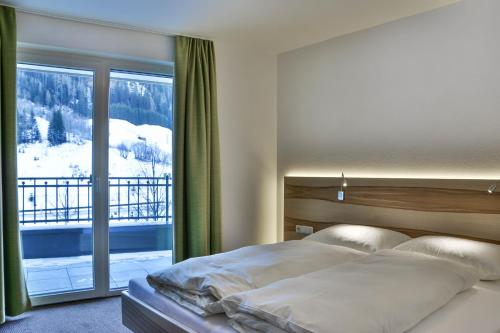 um quarto com uma cama e uma grande janela em Appartements Plaija em Sankt Anton am Arlberg