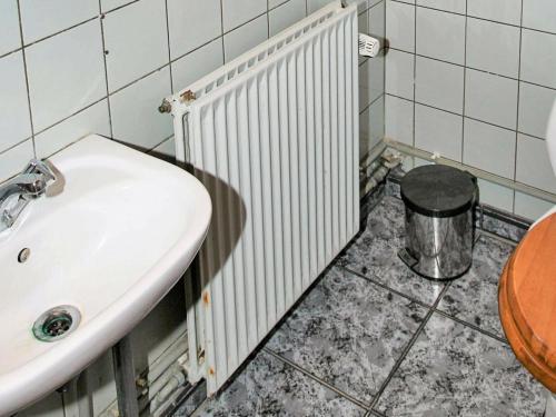 a bathroom with a sink and a trash can at Two-Bedroom Holiday home in Svaneke 4 in Svaneke