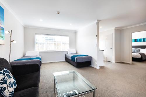a living room with a couch and a table at Beach Street Motel Apartments in New Plymouth