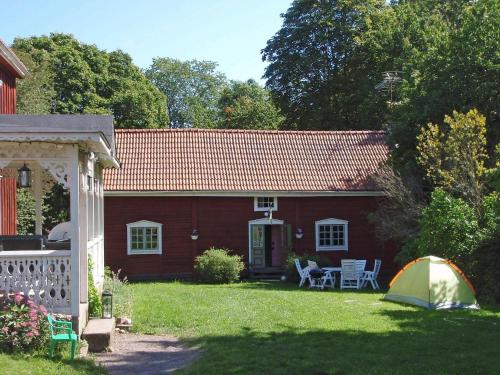 a red house with a tent in the yard at 8 person holiday home in VIMMERBY in Rumskulla