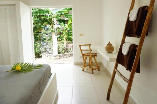 a room with a bed and a chair and a window at Le BDM PLAYITA in Las Galeras