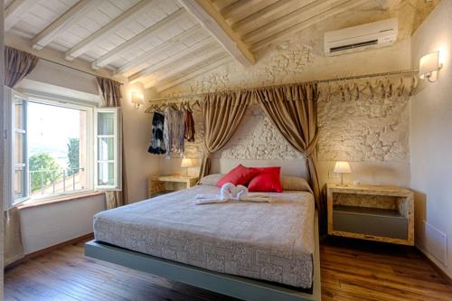 a bedroom with a large bed with red pillows at Il Maramaldo Bed&Breakfast-Restaurant in Lajatico