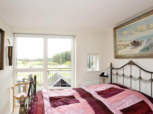 ein Schlafzimmer mit einem Bett und einem großen Fenster in der Unterkunft Three-Bedroom Holiday home in Løkken 22 in Løkken