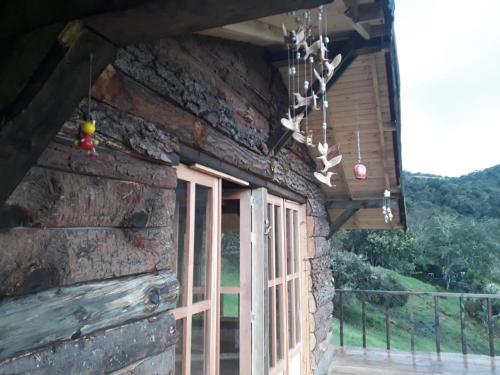 porche de una cabaña de madera con ventana en CABAÑA LA LIBELULA, en San Ignacio