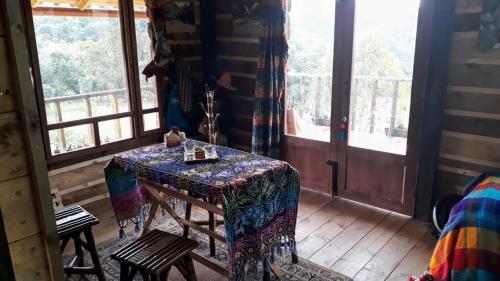 Habitación con mesa en una habitación con ventanas en CABAÑA LA LIBELULA, en San Ignacio