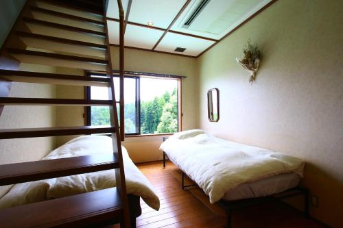 Tsukitei في Minami Aso: غرفة نوم بسريرين بطابقين ودرج