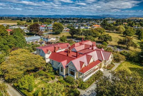 uma vista superior de uma casa grande com um telhado vermelho em Pen-y-bryn Lodge em Oamaru