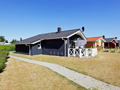 Un granero negro con una bandera americana. en 6 person holiday home in GROEMITZ en Grömitz