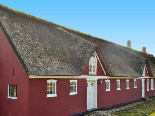 czerwony budynek z dachem krytym strzechą w obiekcie 4 person holiday home in Fan w mieście Fanø