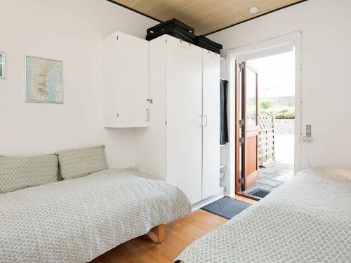 a bedroom with two beds and a door to a balcony at Holiday Home Lyngvejen VI in Rømø Kirkeby