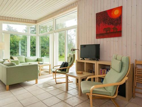 Knebelにある6 person holiday home in Knebelのリビングルーム(テレビ、ソファ、椅子付)