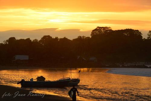 a boat sitting on the water at sunset at La Casa Mompiche in Mompiche