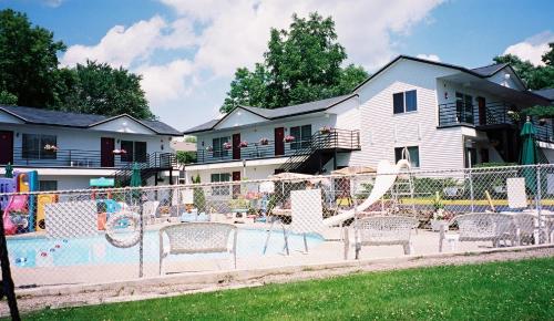 un parque infantil con sillas frente a una casa en Spring Hill Motel, en Wisconsin Dells