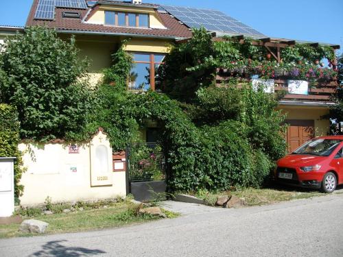 a red car parked in front of a house at Penzion U Lesa in České Budějovice