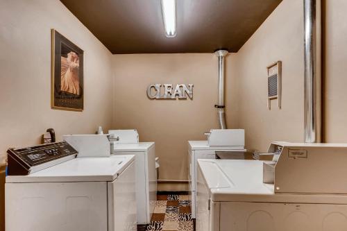 een kamer met witte wasmachines en een bord aan de muur bij Inn the Clouds Hostel & Inn in Leadville