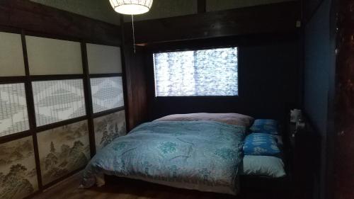 Giường trong phòng chung tại 築100年の宿【はぶの家】