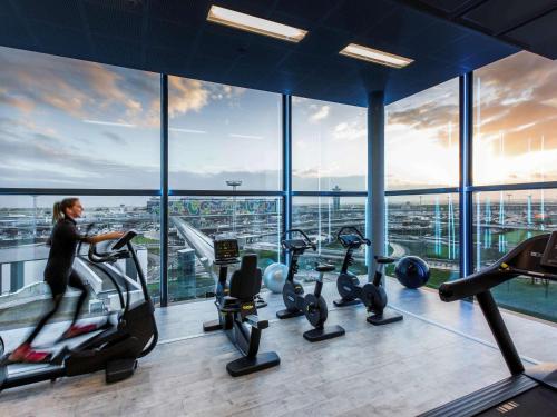 a woman running on a treadmill in a gym at Novotel Paris Coeur d'Orly Airport in Orly
