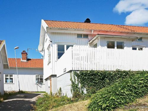 una cerca blanca frente a una casa blanca en 6 person holiday home in H LLEVIKSSTRAND, en Hälleviksstrand