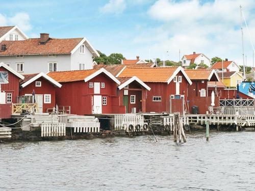 un grupo de casas rojas junto a un cuerpo de agua en 6 person holiday home in H LLEVIKSSTRAND, en Hälleviksstrand