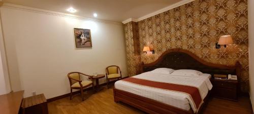 a hotel room with a bed and a table and chairs at Hoang Yen Hotel in Thuan An