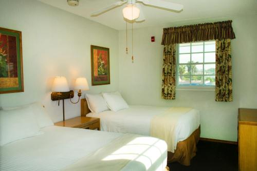 um quarto de hotel com duas camas e uma janela em The Beach Cottages em San Diego