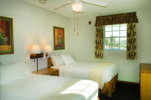 a hotel room with two beds and a window at The Beach Cottages in San Diego