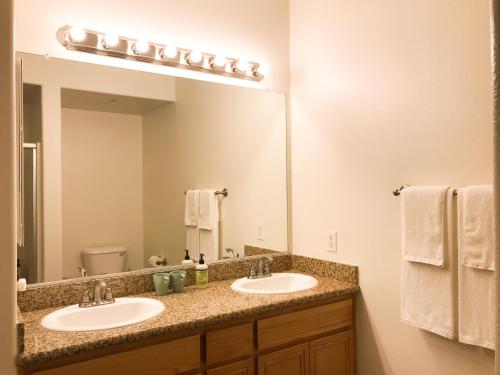 a bathroom with two sinks and a large mirror at Perfect Apt near UCLA w Parking Gym Pool WIFI in Westwood B3 in Los Angeles