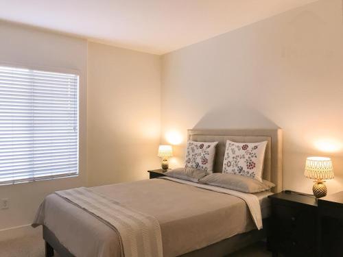 a bedroom with a bed with two lamps and a window at Perfect Apt near UCLA w Parking Gym Pool WIFI in Westwood B3 in Los Angeles