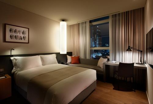 首爾的住宿－Shilla Stay Seocho Gangnam Station，酒店客房设有一张大床和一张沙发。