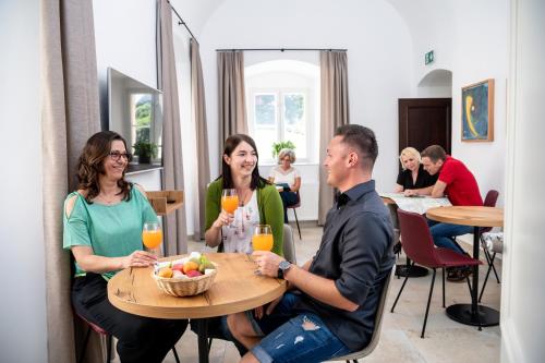 a group of people sitting at a table with orange juice at Gästehaus Benediktinerstift Göttweig - Bed & Breakfast Monastery in Furth
