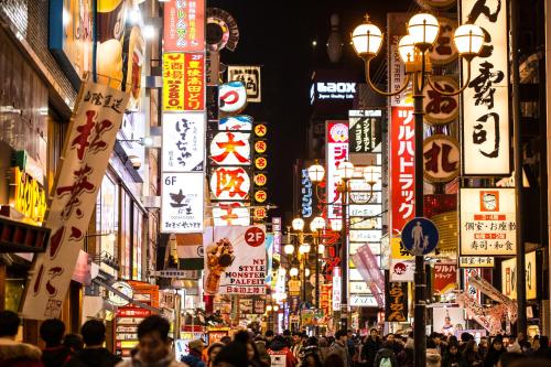 a busy city street at night with many signs at Cross Hotel Osaka in Osaka